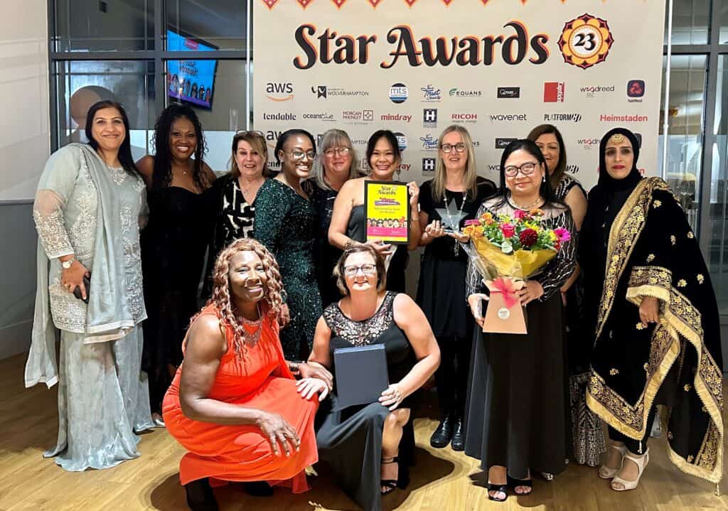 A group of women holding an award they won at an NHS staff awards night.